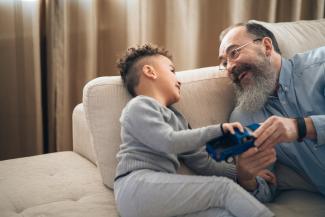 A man and grandchild sitting on a couch