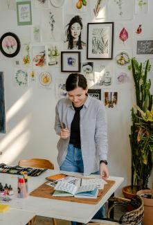 a woman looking over papers on a table