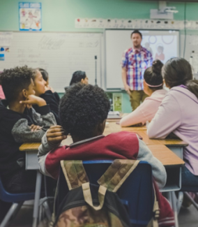Children in a classroom looking at the teacher